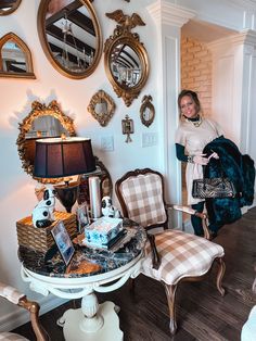 a woman standing next to a white table in a room with mirrors on the wall