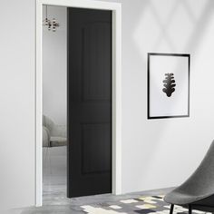 an empty room with a black door and chair