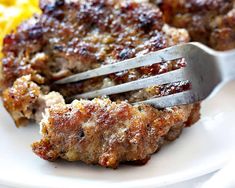 a close up of a fork on a plate with meat