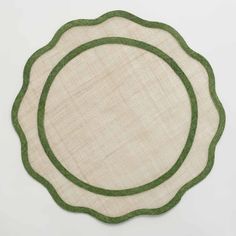 a green and white placemat on a white surface with an oval design in the middle