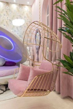 a bedroom with a birdcage hanging from the ceiling next to a pink chair