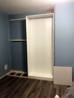 an empty room with blue walls and wood flooring in the process of remodeling