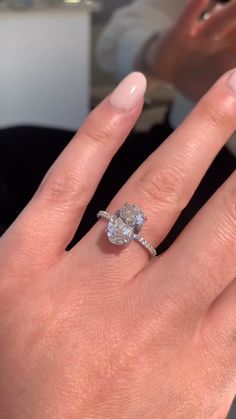 a woman's hand with a diamond ring on it