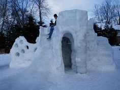 a man standing on top of an igloose in the snow