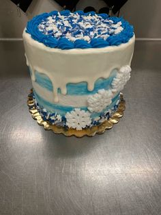 a blue and white frosted cake sitting on top of a table