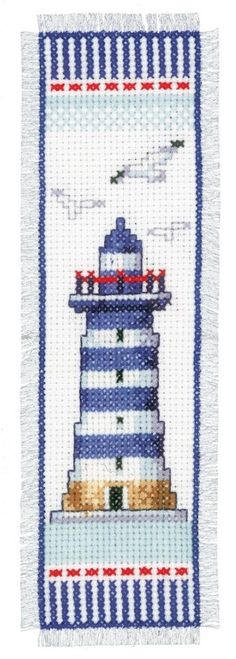 a blue and white lighthouse is shown on the side of a piece of fabric with an embroidered border