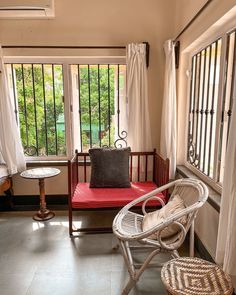 a chair and table in a small room with large windows on both sides of the room