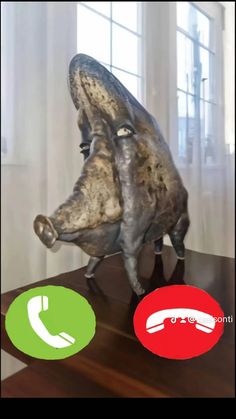 an animal statue on a wooden table next to a phone