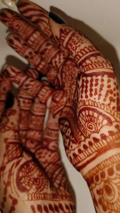 two hands that are holding something in each other's hand with hendi designs on them