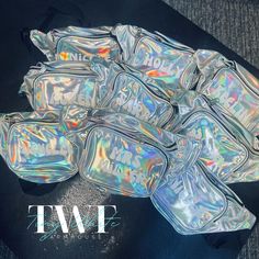 holographic fanny bags are stacked on the floor