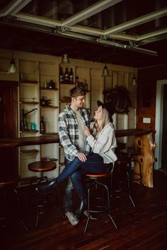 a man and woman sitting on top of chairs in a kitchen next to each other