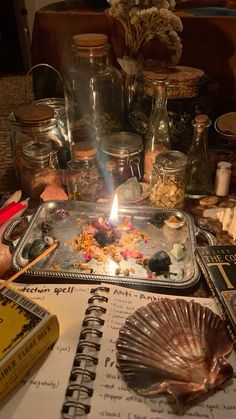 a candle is lit in the middle of a table full of jars and other items