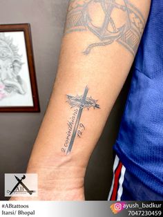 a man with a cross tattoo on his arm