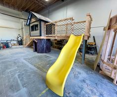 a yellow slide is in the middle of a room with other furniture and construction materials