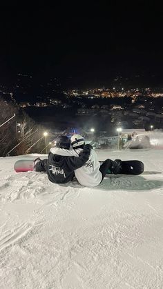 a snowboarder laying on the ground at night