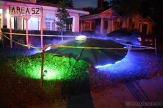 an umbrella is lit up in front of a house with police tape on the ground