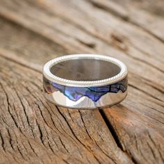 a silver ring sitting on top of a wooden table