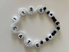 a beaded bracelet with letters that spell out love and peace in black and white beads