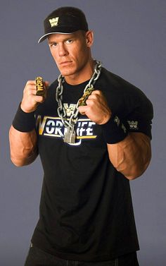 a man with a chain around his neck and wearing a black shirt holding two gold chains