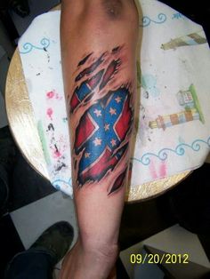 a person with a tattoo on their arm that has an american flag in the shape of a heart