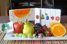 an assortment of fruit on a white plate with cards and pictures in front of it