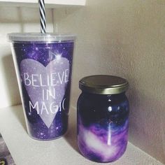 a cup with a straw sitting next to a jar that says believe in magic on it