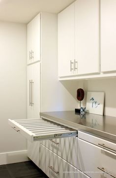 an empty kitchen with white cabinets and drawers