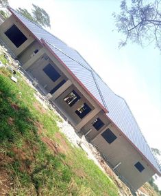 a building that is on the side of a hill with grass growing up to it