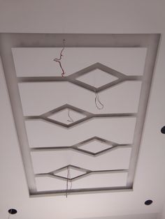 the ceiling is painted white and there are wires hanging from it's holes in the ceiling