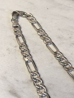 "Sterling Silver Unisex Solid Link Figaro Chain Necklace 18\" in Length. This chain is very flexible and comfortable to wear with its shiny bright plain polished finish. This chain has finished end caps and a lobster claw clasp closure and is 7mm wide and weighs 28.1 grams. This item would Retail for $429.00" Gold Jacket, Figaro Chain Necklace, Earring Jackets, Figaro Chains, Figaro Chain, Link Chain Necklace, Chain Link Necklace, Gold Hoop, Mens Wedding Bands