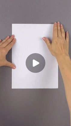 two hands holding up a white piece of paper