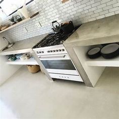 a white stove top oven sitting inside of a kitchen next to a counter with plates on it