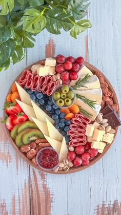 a platter filled with different types of cheese and fruit