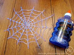 a spider web is next to a bottle of glue