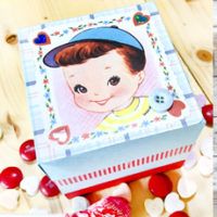 an image of a child's birthday card in a box with candies around it