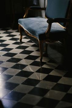 a chair sitting on top of a black and white checkered floor