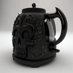 a black coffee pot with a skull design on the front and side, sitting on a white surface