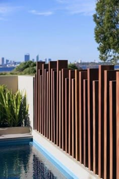 an outdoor swimming pool next to a wooden fence