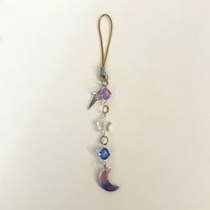 a keychain with charms hanging from it's side on a white surface