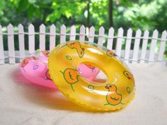 two inflatable donuts are sitting on the ground near a white picket fence