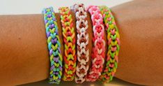 a person's arm with several bracelets on top of each other in different colors