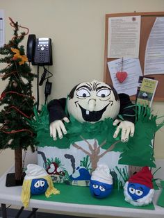 a table topped with lots of fake plants next to a phone and a christmas tree