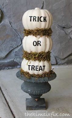 three white pumpkins stacked on top of each other with the words trick or treat written on them