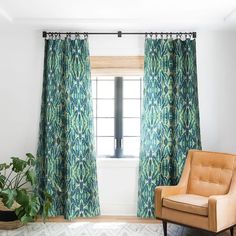 a living room with a chair, window and potted plant