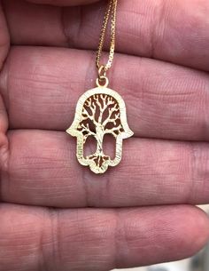 New! New!   Beautiful gold filled Tree of life Hamsa necklace set on a dainty and feminine 14k Gold Filled Chain. The Hamsa is an ancient Middle Eastern amulet symbolizing the Hand of God. In all faiths it is a protective sign. It brings it's owner happiness, luck, health, and good fortune. Necklace measurements on model is 16inch size 1.5X2cm 0.59X0.78inch This necklace will be Packed perfectly in a gift box with an organza bag. Also ready for giving as a gift. View more dainty Necklaces ~ https://www.etsy.com/il-en/shop/DoronJewelry?section_id=16043125&ref=shopsection_leftnav_1 https://www.etsy.com/il-en/shop/DoronJewelry?ref=shopsection_shophome_leftnav GIFT IT I can ship to a third party if you wish your item to be a gift. Please let me know and I will include a cute little card with a Symbolic Gold Jewelry With Tree Of Life, Nickel-free Gold Plated Spiritual Necklaces, Holistic Gold Pendant Jewelry, Spiritual Tree Of Life Jewelry For Gifts, Spiritual Tree Of Life Jewelry Gift, 14k Gold Tree Of Life Pendant Jewelry, Yellow Gold Tree Of Life Pendant Jewelry, Spiritual Tree Of Life Jewelry As A Gift, Elegant Gold Necklace With Tree Of Life