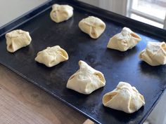 eight uncooked dumplings on a baking sheet ready to go into the oven