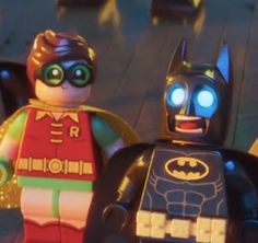 two lego batmans are standing next to each other