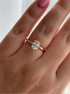 a woman's hand with a ring on it and a diamond in the middle