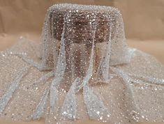 a white sequin covered hat sitting on top of a table