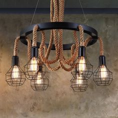 a chandelier with five light bulbs hanging from it's center and rope wrapped around the lights